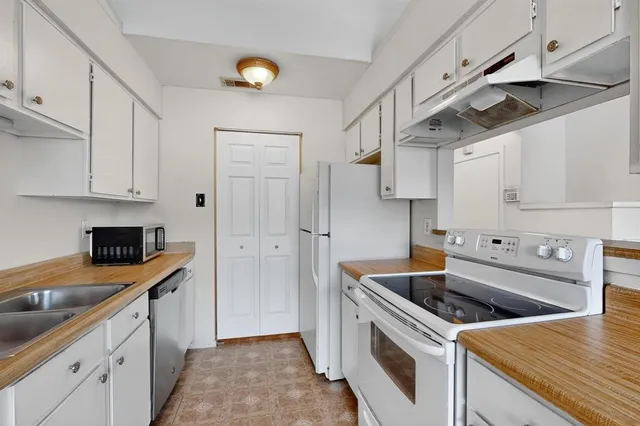 a kitchen with stainless steel appliances granite countertop a sink and a stove