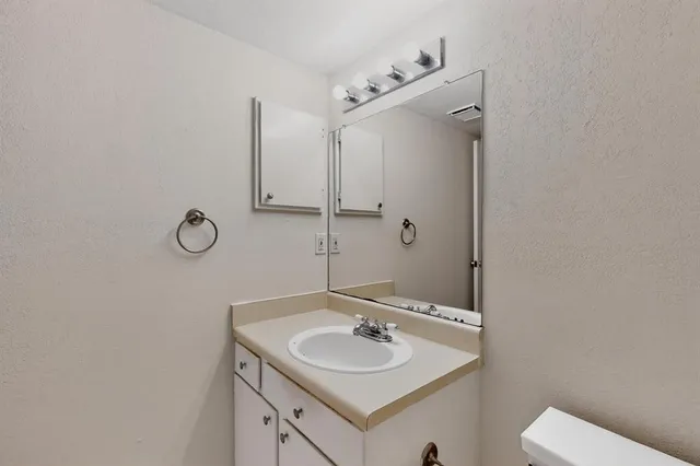 a bathroom with a sink toilet and mirror