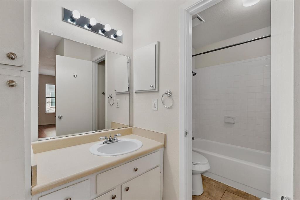 2240 Tarpley Road, Unit 242 Carrollton, TX 75006 - Photo 28 of 30 a bathroom with a sink a toilet a mirror and shower