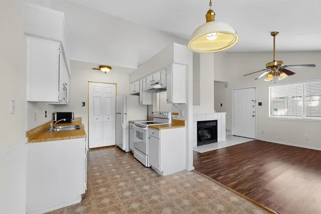 a kitchen that has a lot of cabinets and wooden floor