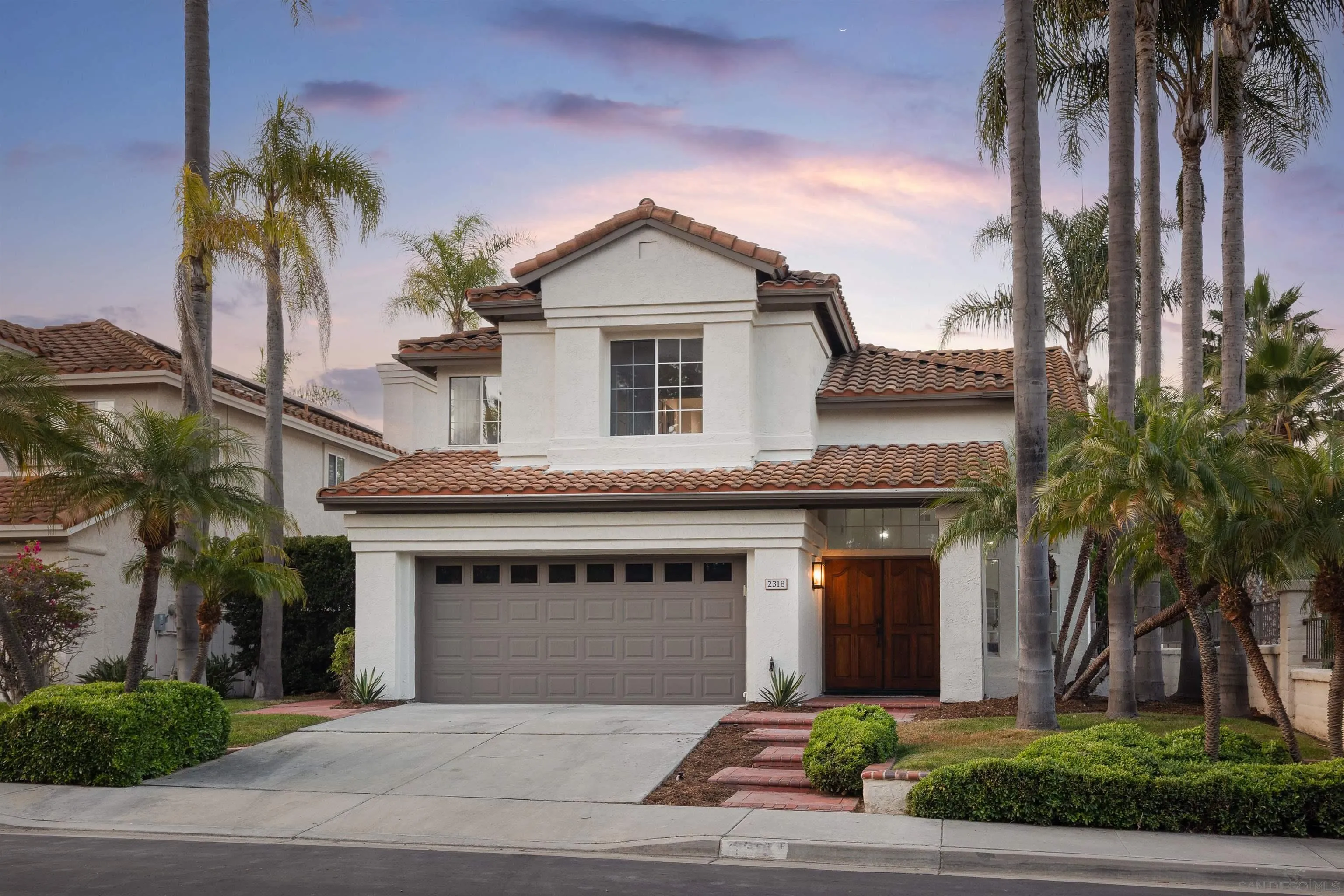 2318 Via Villegas Carlsbad, CA 92009 - Photo 2 of 37 a front view of a house with a garden and palm trees