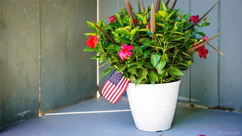 a white vase with white and yellow flowers