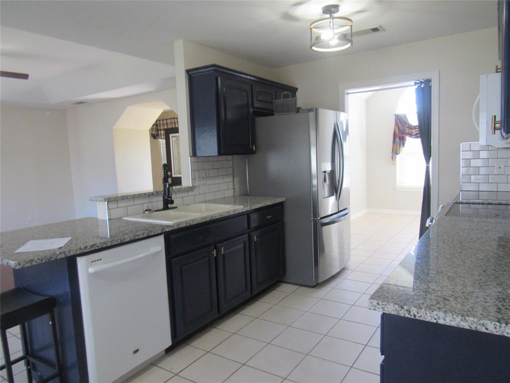 4019 East Fm 120 Denison, TX 75021 - Photo 13 of 39 a kitchen with stainless steel appliances granite countertop a sink refrigerator and microwave