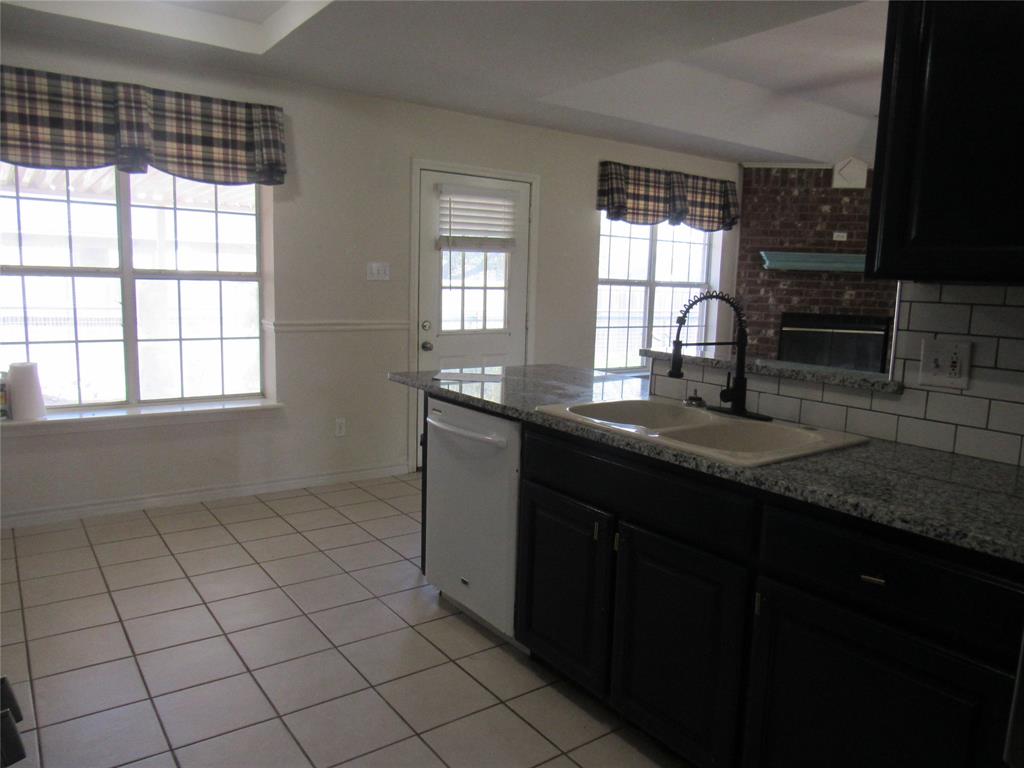4019 East Fm 120 Denison, TX 75021 - Photo 17 of 39 a kitchen with granite countertop a sink window and cabinets