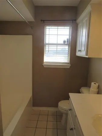 a bathroom with a sink a toilet and a window