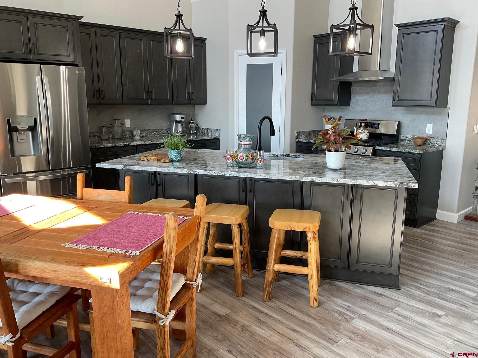 24203 Valley View Circle Cedaredge, CO 81413 - Photo 11 of 41 a kitchen with stainless steel appliances granite countertop table chairs sink refrigerator and stove