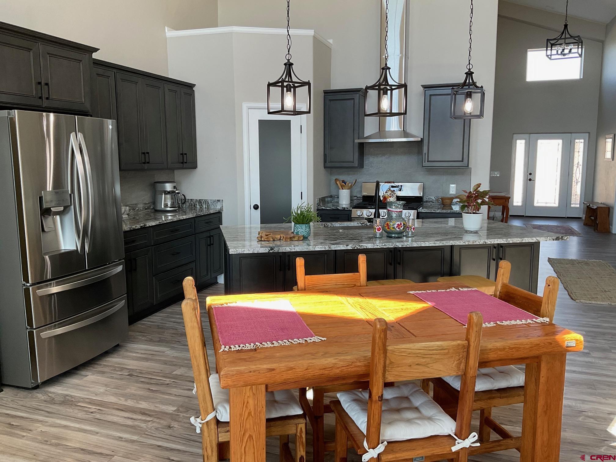 24203 Valley View Circle Cedaredge, CO 81413 - Photo 12 of 41 a kitchen with stainless steel appliances kitchen island granite countertop a dining table and chairs