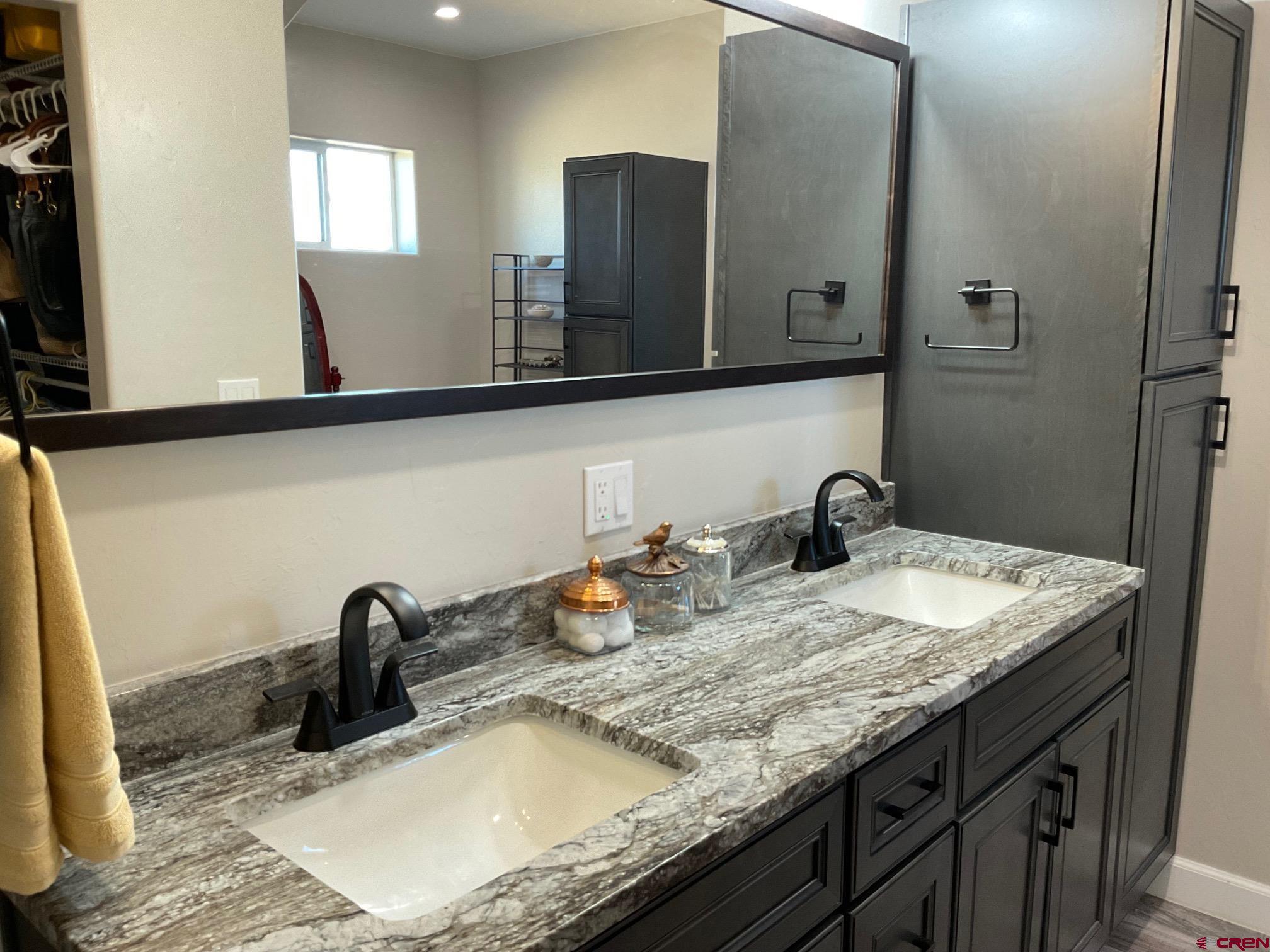 24203 Valley View Circle Cedaredge, CO 81413 - Photo 19 of 41 a bathroom with sink granite and a mirror