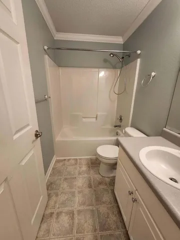 a bathroom with a granite countertop sink toilet a mirror and shower
