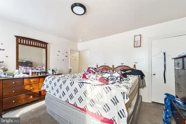 a bedroom with a bed dresser and a window