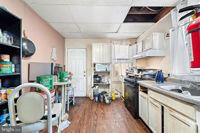 a kitchen with a sink a stove and chairs