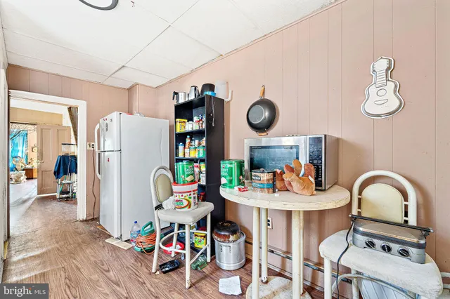a bathroom with a sink a toilet and a wooden floor