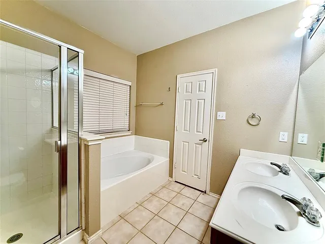 a bathroom with a tub sink and mirror