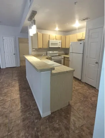 a kitchen with refrigerator and cabinets
