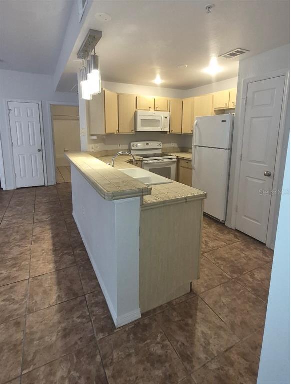 1990 Erving Circle, Unit 102 Ocoee, FL 34761 - Photo 11 of 28 a kitchen with refrigerator and cabinets