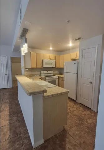 a kitchen with refrigerator and cabinets