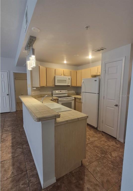 1990 Erving Circle, Unit 102 Ocoee, FL 34761 - Photo 14 of 28 a kitchen with refrigerator and cabinets