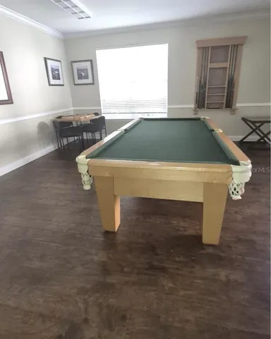 a room with pool table and windows