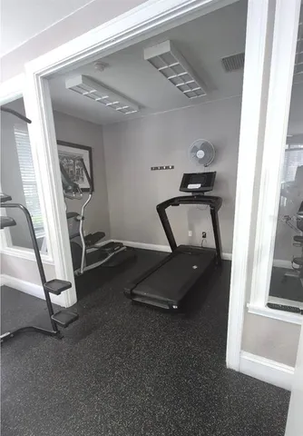 a room with gym equipment and a view of living room