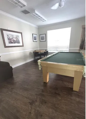 a room with pool table and windows