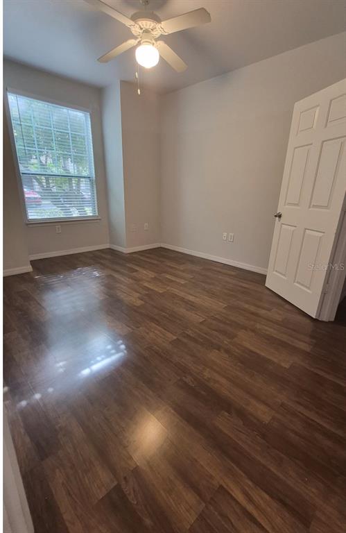 1990 Erving Circle, Unit 102 Ocoee, FL 34761 - Photo 5 of 28 an empty room with wooden floor and windows