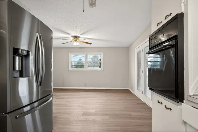 a view of a kitchen with wooden floor a kitchen view and a fireplace