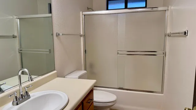 a bathroom with a toilet a sink and vanity