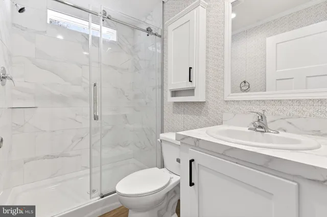 a bathroom with a sink toilet vanity and shower