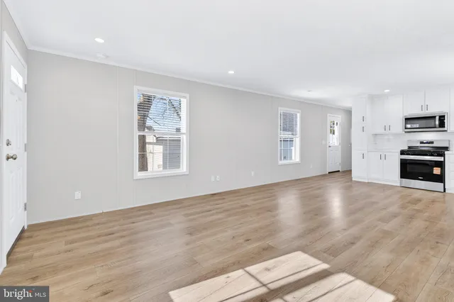 a view of empty room with kitchen and window