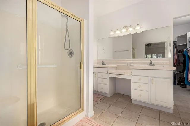 a bathroom with a double vanity sink mirror and shower