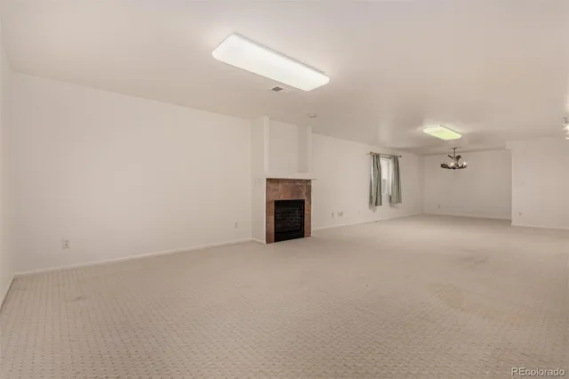 an empty room with a fireplace and a window