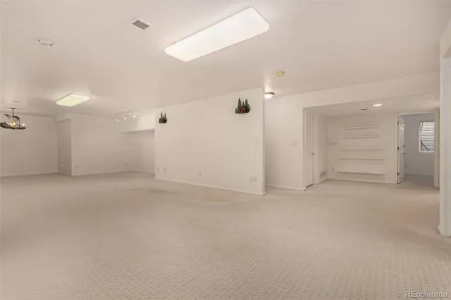 an empty room with white walls and ceiling fan