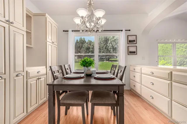 a view of a dining room with furniture a chandelier and wooden floor