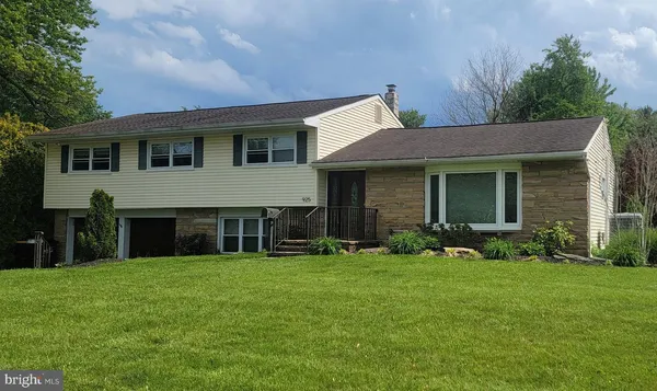a front view of a house with a yard and trees
