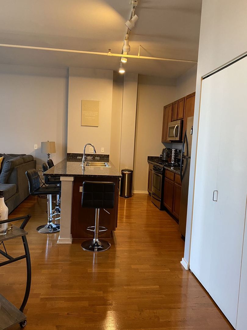 2323 West Pershing Road, Unit 601 Chicago, IL 60609 - Photo 13 of 21 a view of a kitchen with kitchen island dining table and wooden floor