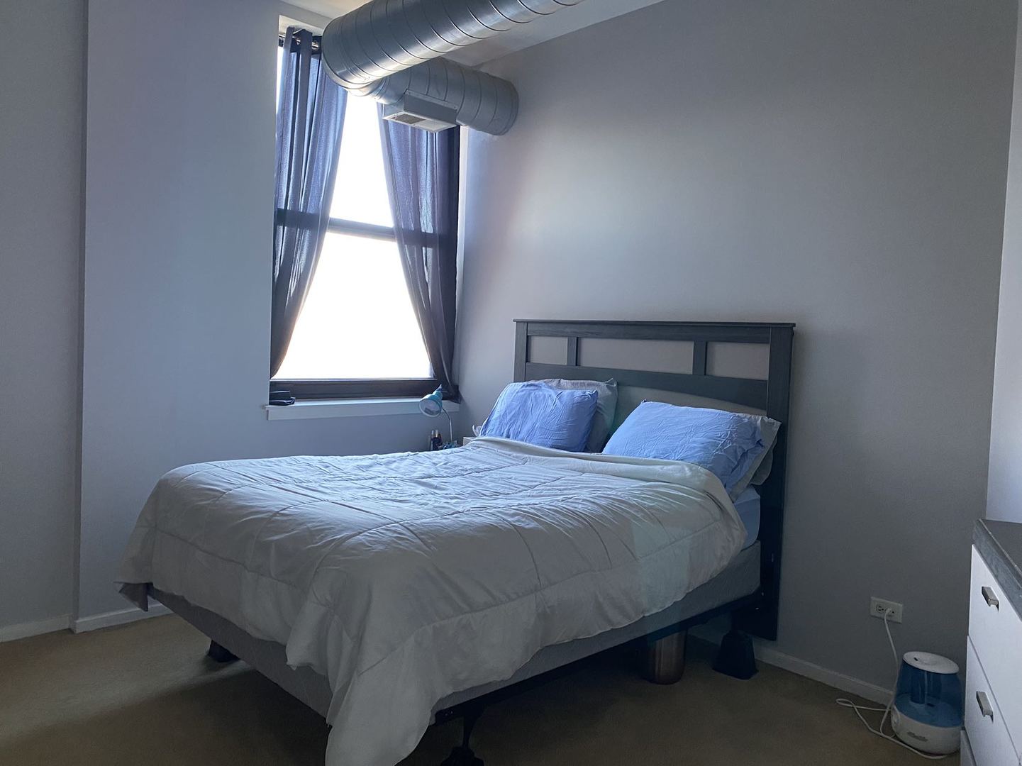 2323 West Pershing Road, Unit 601 Chicago, IL 60609 - Photo 17 of 21 a bed sitting in a bedroom next to a window