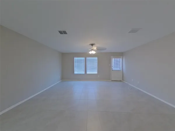 a view of a big room with windows and chandelier fan
