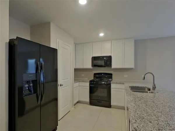 a kitchen with stainless steel appliances granite countertop a refrigerator and a stove