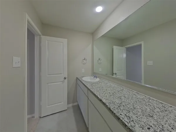 a bathroom with a granite countertop sink and vanity