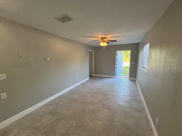 an empty room with an entryway and windows