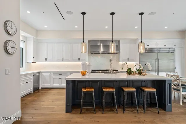 a kitchen with stainless steel appliances a sink a stove top oven a counter space and cabinets