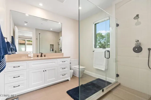a bathroom with a granite countertop sink toilet and shower