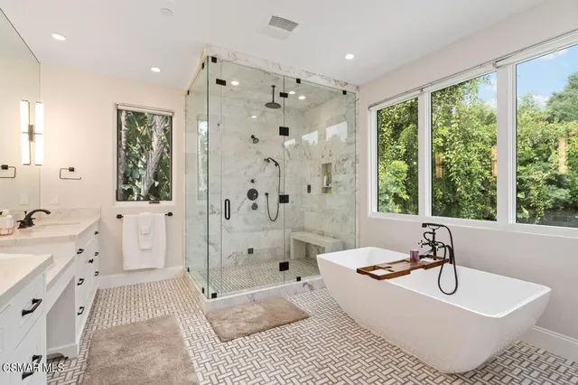 a bathroom with double vanity sink shower and a mirror