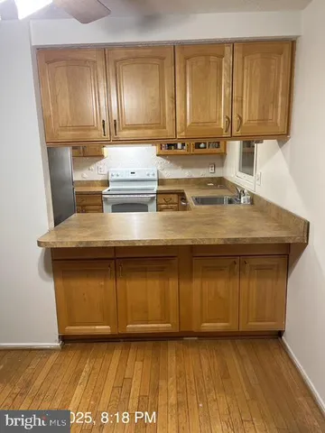 a kitchen with a sink cabinets and a wooden floor