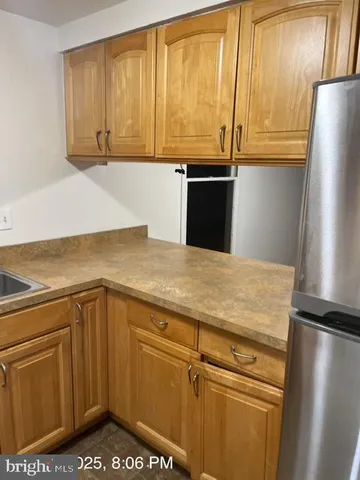 a kitchen with stainless steel appliances granite countertop a refrigerator a stove and a sink