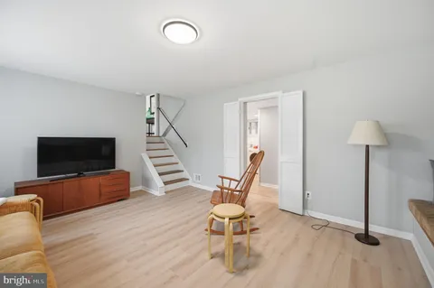 a living room with furniture a flat screen tv and a large window