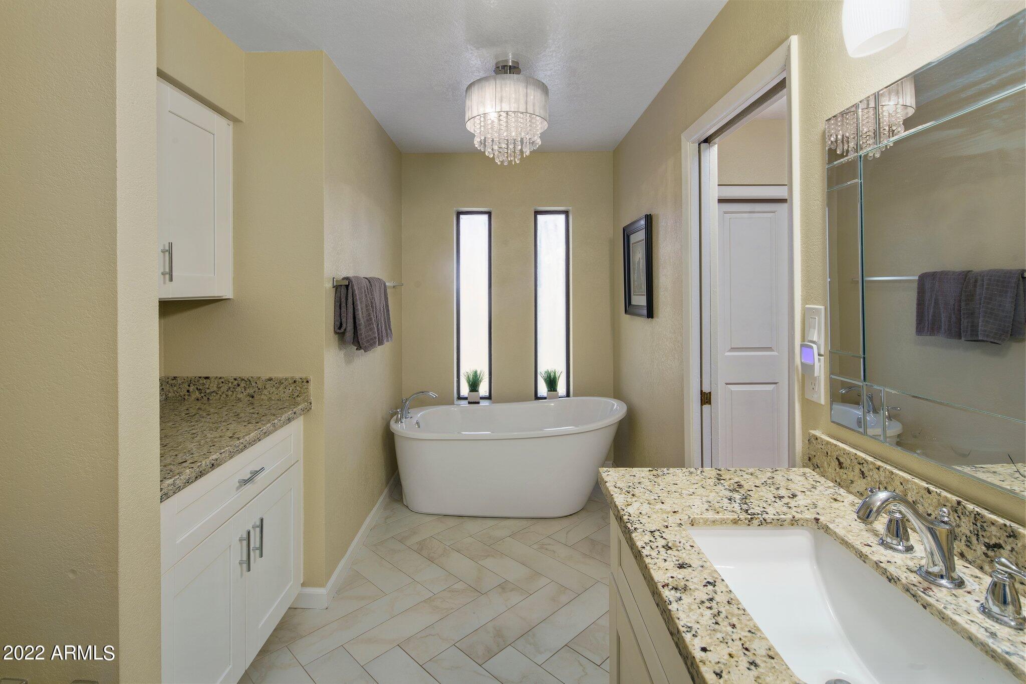 6609 East Phelps Road Scottsdale, AZ 85254 - Photo 56 of 83 a bathroom with a granite countertop sink a toilet a mirror and shower