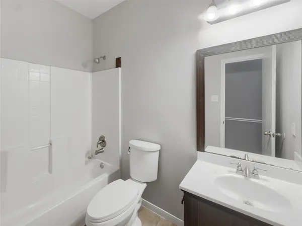 a bathroom with a sink a toilet a mirror and shower