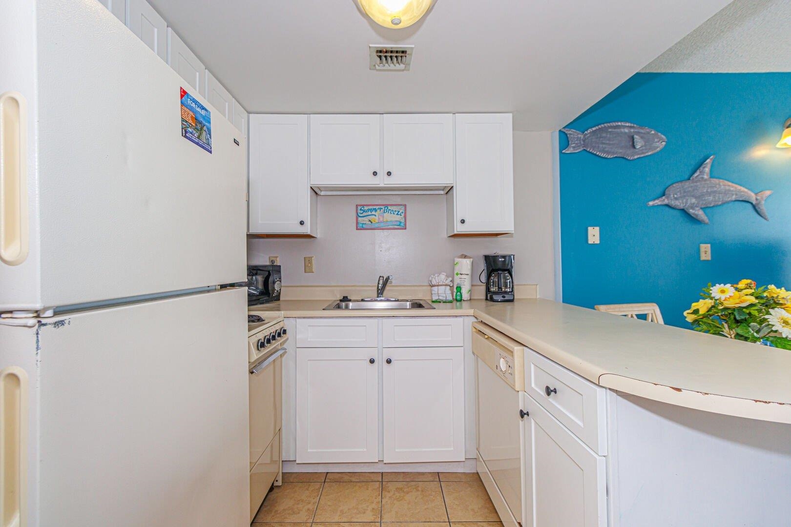 1605 South Ocean Boulevard, Unit 505 Myrtle Beach, SC 29577 - Photo 17 of 38 Kitchen featuring white appliances, white cabinetry, light countertops, and a peninsula