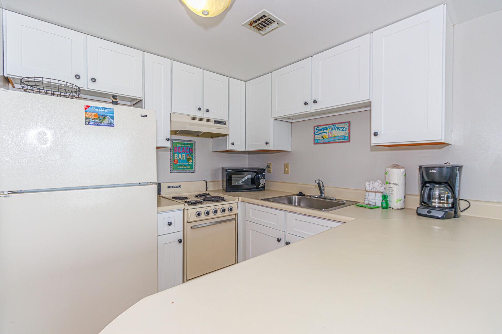 1605 South Ocean Boulevard, Unit 505 Myrtle Beach, SC 29577 - Photo 20 of 38 Kitchen with white appliances, light countertops, white cabinetry, and under cabinet range hood